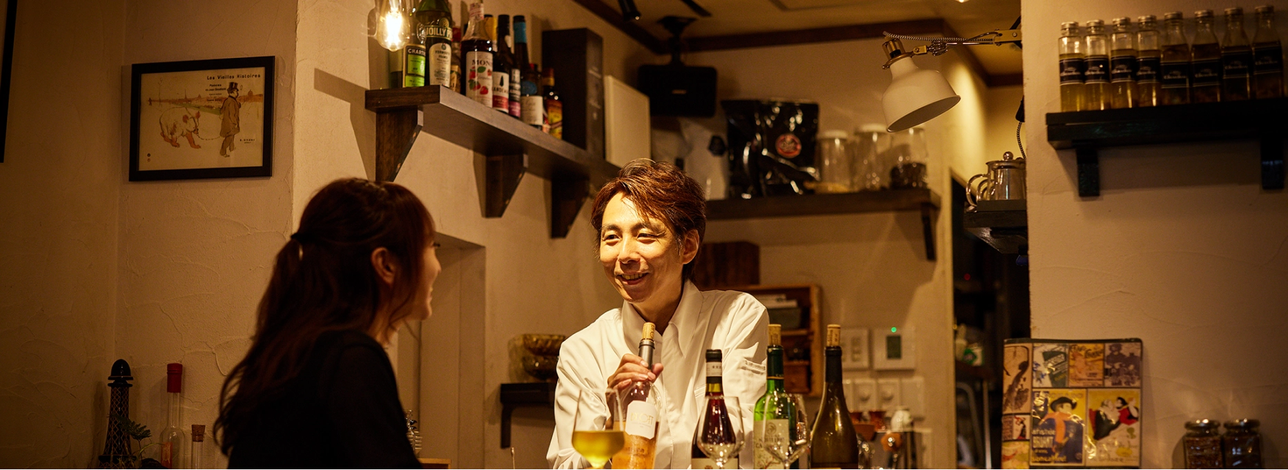 シェフと女性客がカウンター席で談笑する様子